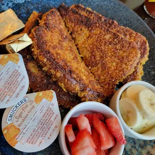 a plate of french toast, strawberries, and yogurt