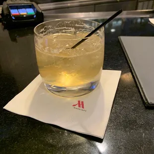 a glass of lemonade on a napkin