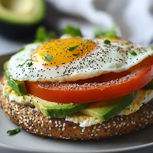 Breakfast bagel with avocado, tomato and Sunny-side up  eggs