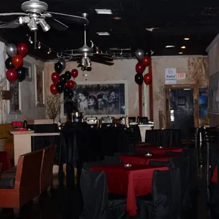 tables and chairs with red and black tablecloths