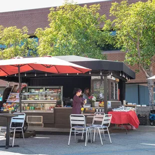 the outside of a restaurant with tables and umbrellas