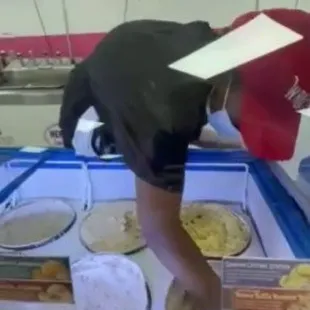 a man bending over to pick up a piece of food