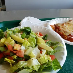 a plate of salad and a plate of lasagna