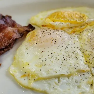 two eggs and bacon on a plate