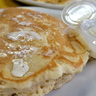 a plate of pancakes with butter and syrup