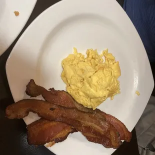 bacon and scrambled eggs on a plate