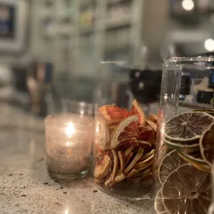 a close up view of a counter with a candle and some dried orange slices