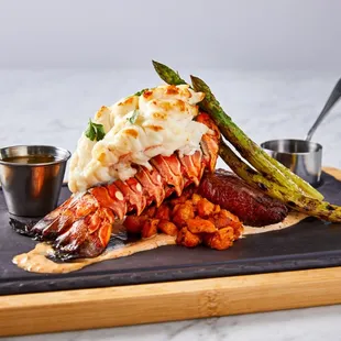 Classic Surf &amp; Turf: Grilled Skirt Steak &amp; Poached, Lobster Tail, Grilled Asparagus, Crispy Smashed Potato.