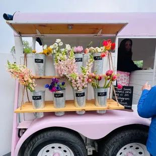 Flower cart with flowers for sale in parking lot on Mother's Day.