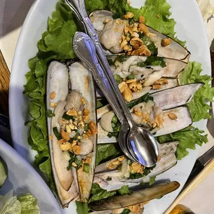 a plate of salad with a spoon and fork