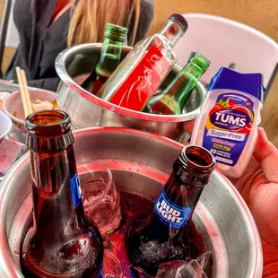 a person holding a bucket full of drinks