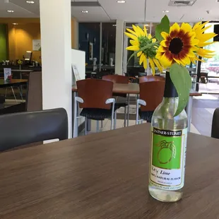 a sunflower in a bottle on a table