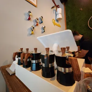 a counter with a variety of coffee pots on it