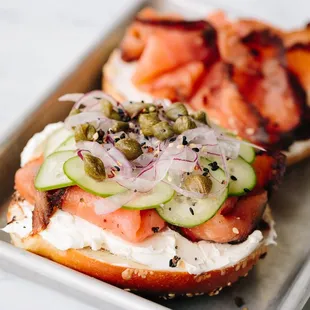 a plate of sandwiches with salmon, cucumbers, and capers