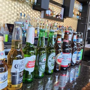 bottles of beer lined up on a bar