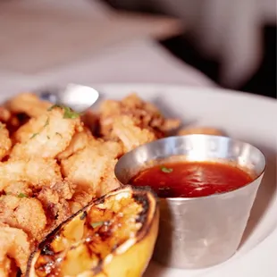 a plate of fried food with dipping sauce