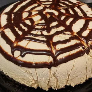a cheesecake with chocolate sauce drizzled on top
