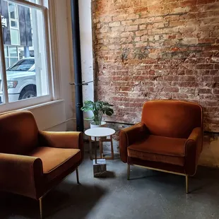 two chairs in front of a brick wall