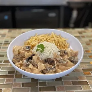 Chicken stroganoff with mushrooms, pilaf rice and sticks potatoes.