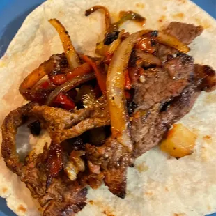 steak and veggies fajitas in a flour tortilla