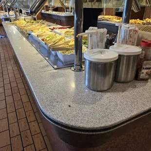 A dead bug on a countertop near the sauce-crusted ketchup sauce pumps
