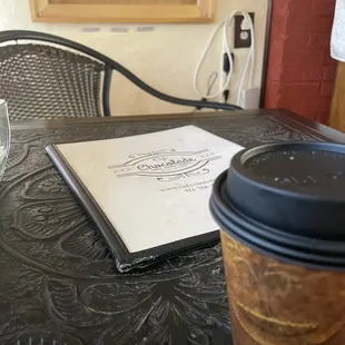 a glass of wine and a book on a table