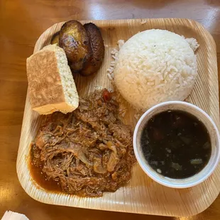 a plate of pulled pork, rice, and beans