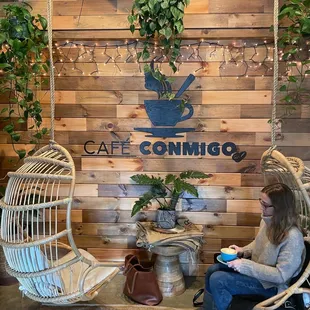 a woman sitting in a wicker chair