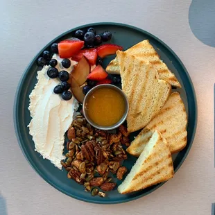 a plate of food with fruit, bread, and nuts