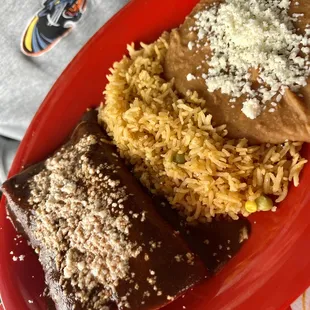 Chicken mole enchiladas, rice and refried pinto beans