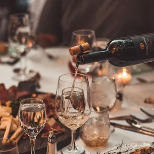 a person pouring wine into a glass