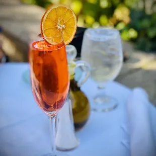 a glass of wine with a slice of orange