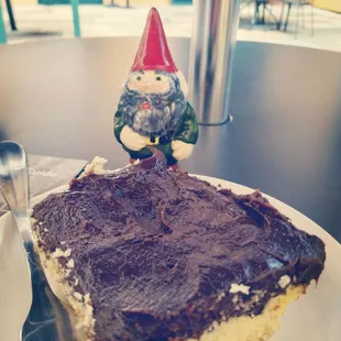 a slice of cake with a gnome figurine on top