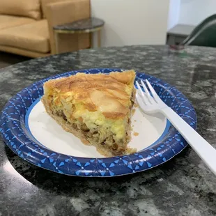 a slice of quiche on a blue and white plate