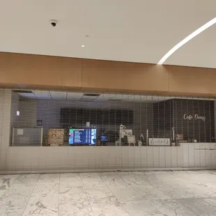 Located towards the back of the entrance... pass the escalators