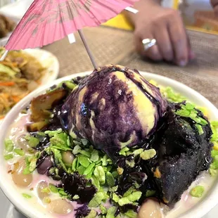 a bowl of food with ice cream and a pink umbrella