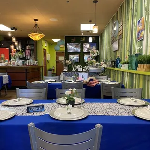 a blue table cloth with white place settings