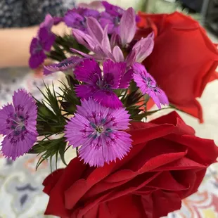 a red rose and purple flowers
