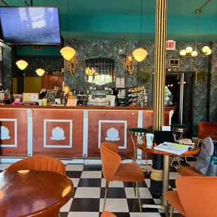 a checkered floor with orange chairs