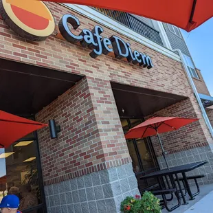 people sitting at tables under umbrellas