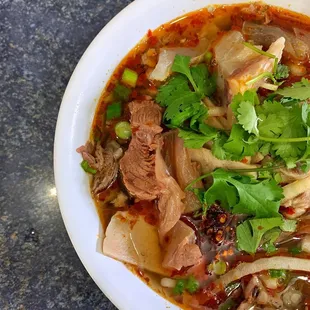 a bowl of soup with meat and vegetables