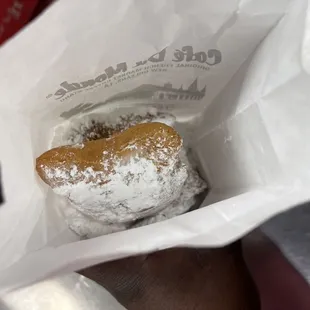 a half eaten donut in a paper bag