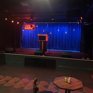 a stage with a podium and chairs