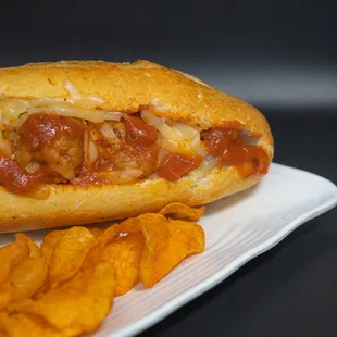 Meatball &amp; cheese sandwich with a side of chips