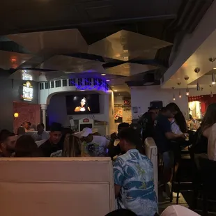 people sitting at tables watching televisions