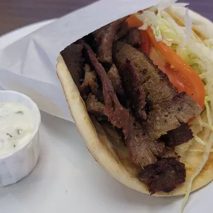 Beef and lamb gyro complete with shredded lettuce, tomatoes. Moist flavorful, even better when stuffed with fries like in Greece.