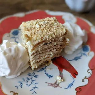a piece of cake on a plate with whipped cream