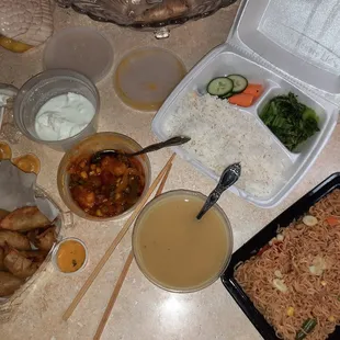 Fried Veggie MoMo, Vegetable Curry, Lentil Soup, WaiWai, Green Leaf and Basmati Rice in the box.