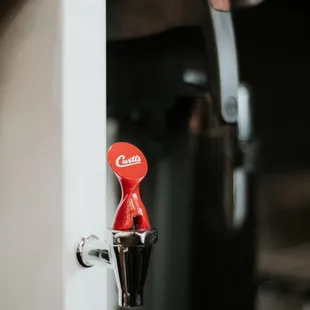 a red coffee maker in the corner of a kitchen