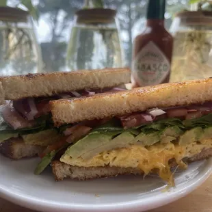 Egg, cheese, avocado, tomato, spinach, and onion sandwich